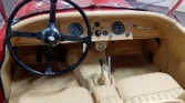 Restored beige leather interior of a 1954 Jaguar XK120.