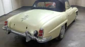 Side view of a 1956 Mercedes Benz 190SL showcasing its sleek convertible design and metallic cream mist color