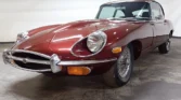 Front view of a 1970 Jaguar E-Type 4.2 (2+2) with a new metallic maroon paint job