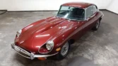 Front view of a 1970 Jaguar E-Type 4.2 (2+2) with a new metallic maroon paint job