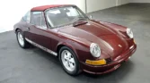 Front view of a 1972 Porsche 911 Targa with a new metallic maroon paint job.