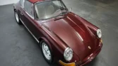 Front view of a 1972 Porsche 911 Targa with a new metallic maroon paint job.