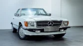 Front view of a 1988 Mercedes Benz 560SL for sale, a classic car with an Arctic White exterior. Auto Mart Motors