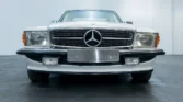 Front view of a 1988 Mercedes Benz 560SL for sale, a classic car with an Arctic White exterior. Auto Mart Motors