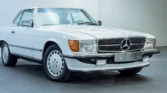 Front view of a 1988 Mercedes Benz 560SL for sale, a classic car with an Arctic White exterior. Auto Mart Motors