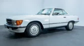 Side view of a 1988 Mercedes Benz 560SL for sale, showcasing its vintage convertible design in Arctic White. Auto Mart Motors